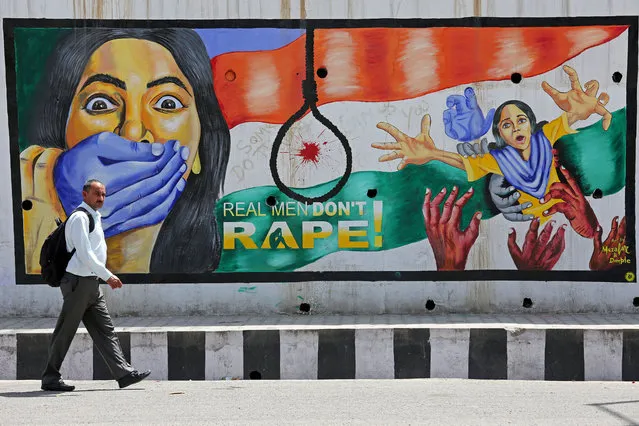 A man walks past a graffiti depicting a message in protest against rape, in Jammu, April 22, 2018. (Photo by Mukesh Gupta/Reuters)