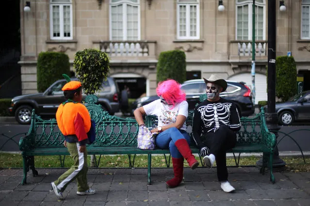 A couple with faces painted as popular Mexican figure “Catrina” give candy to a child during the annual Catrina Fest, part of Day of the Dead celebrations, in Mexico City, Mexico, November 2, 2016. (Photo by Edgard Garrido/Reuters)