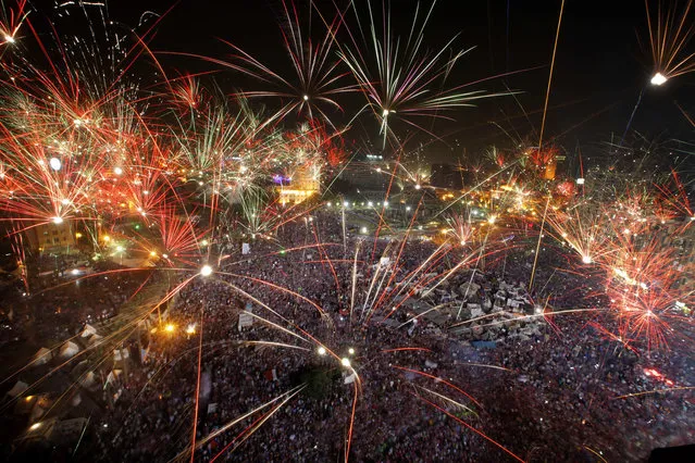 Fireworks light the sky opponents of Egypt's Islamist President Mohammed Morsi celebrate in Tahrir Square in Cairo, Egypt, Wednesday, July 3, 2013. A statement on the Egyptian president's office's Twitter account has quoted Mohammed Morsi as calling military measures “a full coup”. The denouncement was posted shortly after the Egyptian military announced it was ousting Morsi, who was Egypt's first freely elected leader but drew ire with his Islamist leanings. The military says it has replaced him with the chief justice of the Supreme constitutional Court, called for early presidential election and suspended the Islamist-backed constitution.(Photo by Amr Nabil/AP Photo)