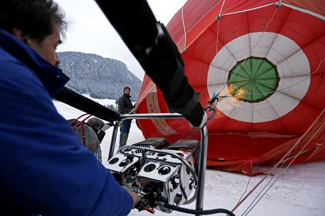 A pilot inflates his balloon before the 37th International Hot Air Balloon Week in Chateau-d'Oex, January 24, 2015. (Photo by Pierre Albouy/Reuters)