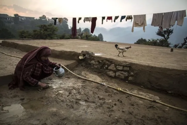 A girl tries to fix the cracked ground outside her house on Margalla Hills in Islamabad January 22, 2015. (Photo by Zohra Bensemra/Reuters)