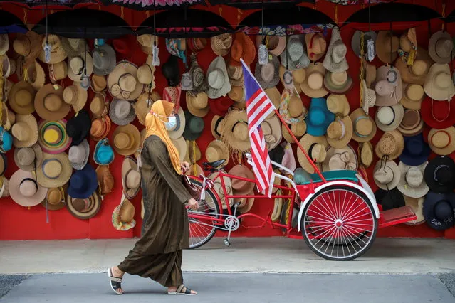 A woman wearing a protective mask walks past a souvenir shop, amid the coronavirus disease (COVID-19) outbreak in Kuala Lumpur, Malaysia on January 12, 2021. (Photo by Lim Huey Teng/Reuters)