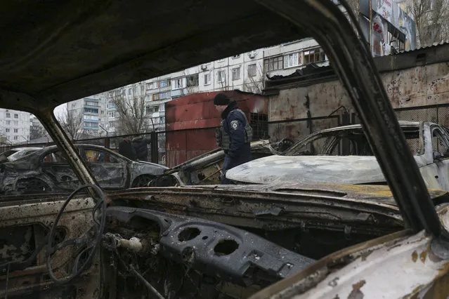 A policeman passes between burnt cars which were destroyed in a shelling on January 24 in the eastern Ukrainian city of Mariupol, January 26, 2015. The pro-Western government in Ukraine announced January 25 that it plans to bring charges before the International Criminal Court (ICC) in The Hague against the pro-Russian separatists it blames for the large number of civilian deaths in the east of Ukraine. (Photo by Sergey Vaganov/EPA)
