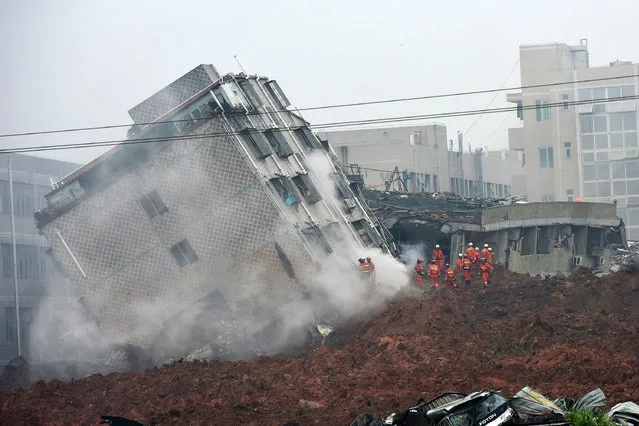Rescuers search for survivors on a collapsed building following a landslide in Shenzhen, in south China's Guangdong province, Sunday, December 20, 2015. (Photo by Chinatopix via AP Photo)