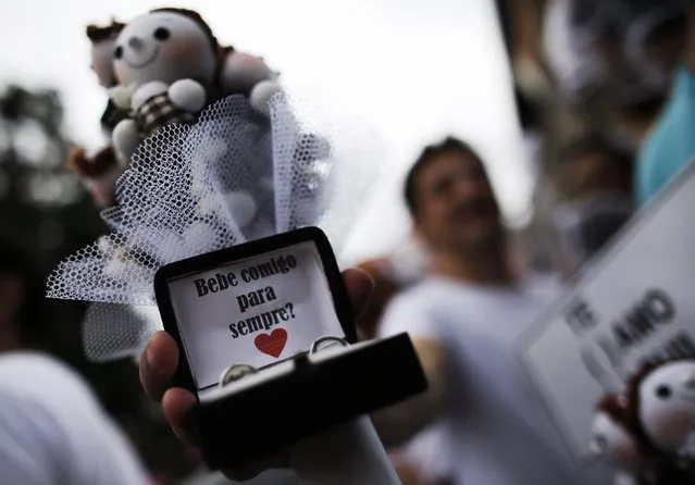 A reveller shows a box with wedding rings he takes part in the annual carnival block party known as “Casas comigo” or “Marry me” at the Vila Madalena neighborhood  in Sao Paulo February 1, 2015. The phrase on the box reads, “Would you drink with me forever?”. (Photo by Nacho Doce/Reuters)