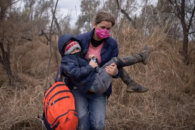 Gabriella, an asylum seeking migrant from Honduras, carries her six year old son Diego as they walk through brush after crossing the Rio Grande river into the United States from Mexico in Penitas, Texas, U.S., March 7, 2021. (Photo by Adrees Latif/Reuters)