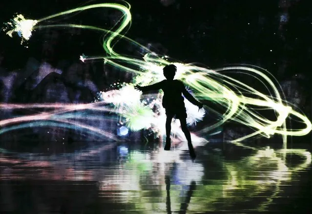 A girl dances in front of the digital art installation “Light in Dark” created by teamLab, a collaborative of Japanese digital artists, during a special exhibition of “Shake! Art Exhibition! and Learn and Play! teamLab Future Park” at National Museum of Emerging Science and Innovation (or Miraikan) in Tokyo, Japan, 19 January 2015. The exhibition is held through 01 March 2015. (Photo by Kimimasa Mayama/EPA)
