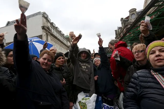 People react as butchers sell their remaining produce of the year at discounted prices during the traditional Christmas Eve auction at Smithfield's market in London  December 24, 2015. (Photo by Neil Hall/Reuters)