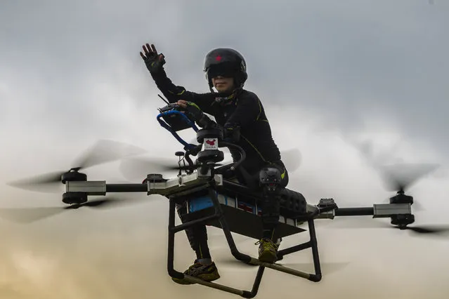 Zhao Deli waves as he pilots his self-made “flying scooter” in Dongguan, Guangdong Province, China, 12 August 2018 (issued 16 August 2018). Inspired by a cartoon he watched as a child, Zhao Deli sold off his apartment in pursuit of his dream of building a flying scooter. The inventor from Dongguan in southern China has invested heavily in his project, which so far has yielded just a test sample – the vehicle's outer shell still needs to be finished. By next year, he hopes to complete the project and send it out for mass production. Customers will have to pay between 38,000 and 50,000 RMB (5,500-7,200 USD) for the flying contraptions, and Zhao hopes to one day make the product available for sale overseas as well. The inventor sees several applications for his flying scooter, from local delivery companies to technical maintenance of various systems, as well as construction. Zhao also believes the scooter could be used for police and military surveillance; it can be easily customized to carry various types of weapons and other necessary equipment.  When asked if anyone from the military had contacted him for possible cooperation, he said “I can't discuss that right now”.  As well as use by officials or security forces, Zhao thinks that the manned drone could prove to be an effective solution to transport congestion, and he predicts an air traffic boom across large cities within 20 years. He also said he expects the Chinese government to pass regulations defining the use of manned drones in urbanized areas. While testing his device Zhao has flown it to a height of 15 meters, although he claims it is capable of soaring to 1,000 meters. He hopes to soon be able to upgrade the drone's battery, which would allow it to fly in a straight line for two hours, as opposed to its current flight capability of 30 minutes. The machine can carry one person, and flies at a top speed of around 70 km/h, with a maximum payload of about 100 kg. (Photo by Aleksandar Plavevski/EPA/EFE)