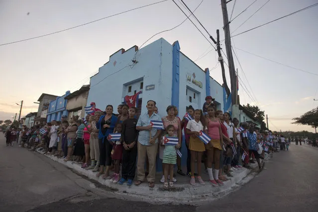 People wait for the arrival of the caravan carrying the ashes of Fidel Castro during a funeral procession that retraces the path of Castro's triumphant march into Havana nearly six decades ago, in Esperanza, Cuba, Wednesday, November 30, 2016. Castro's ashes have begun a four-day journey across Cuba from Havana to their final resting place in the eastern city of Santiago. (Photo by Ricardo Mazalan/AP Photo)