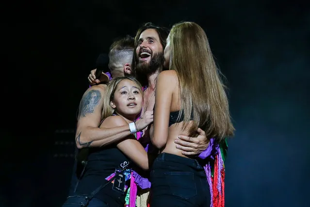 Jared Leto (C), lead singer of US band 30 Seconds to Mars, hugs fans on stage during their concert at the Altice Arena in Lisbon, Portugal, 12 September 2018 as part of their Monolith Tour. (Photo by José Sena Goulão/EPA/EFE)