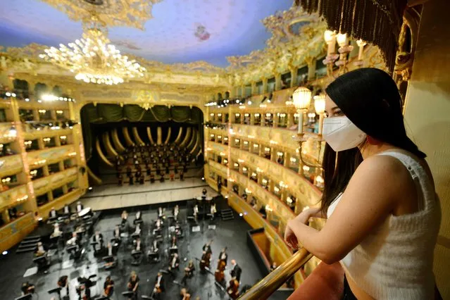A spectator attends the performance of “Verdi e la Fenice” ( Verdi and the Fenice ) at the Fenice Opera theatre to mark the reopening of the Fenice Opera theatre in Venice on April 26, 2021, as bars, restaurants, cinemas and concert halls partially reopen across Italy in a boost for coronavirus-hit businesses, as parliament debates the government's 220-billion-euro ($266-billion) EU-funded recovery plan. After months of stop-start restrictions imposed to manage its second and third waves of Covid-19, Italy hopes this latest easing will mark the start of something like a normal summer. (Photo by Andrea Pattaro/AFP Photo)