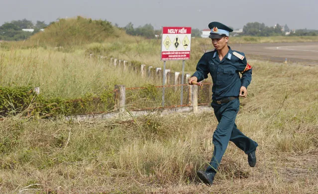 A Vietnamese soldier runs past the dioxin contaminated area when U.S. Secretary of Defense Jim Mattis visited Bien Hoa airbase, where the U.S. army stored the defoliant Agent Orange during the Vietnam War, in Bien Hoa city, outside Ho Chi Minh city, Vietnam, Wednesday, October 17, 2018. (Photo by Kham/Pool Photo via AP Photo)