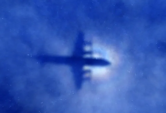 The shadow of a Royal New Zealand Air Force (RNZAF) P3 Orion maritime search aircraft can be seen on low-level clouds as it flies over the southern Indian Ocean looking for missing Malaysian Airlines flight MH370 in this March 31, 2014 file photo. The search for missing Malaysia Airlines Flight MH370 cannot go on forever, Australia's deputy prime minister said, and discussions are already under way between Australia, China and Malaysia as to whether to call off the hunt within weeks. No trace has been found of the Boeing 777 aircraft, which disappeared a year ago this week carrying 239 passengers and crew, in what has become one of the greatest mysteries in aviation history. Picture taken March 31, 2014.   REUTERS/Rob Griffith/Pool/File