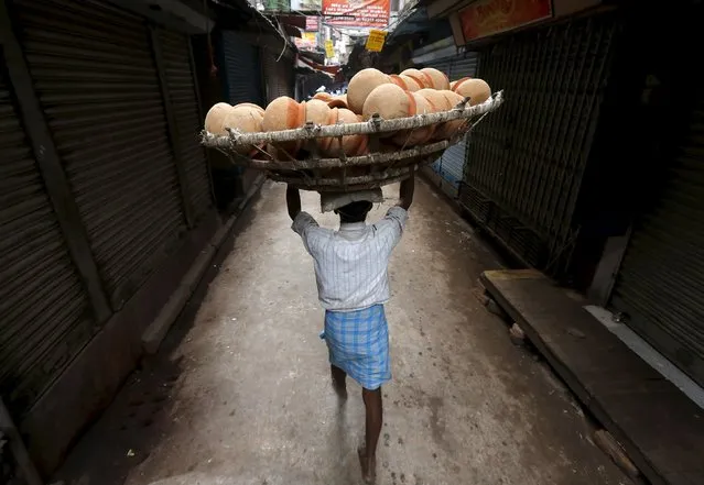 A man carries a basket filled with earthen pots for delivery to a sweet shop through an alley at a market place in Kolkata, India, January 20, 2016. (Photo by Rupak De Chowdhuri/Reuters)