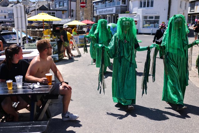 People look as Extinction Rebellion activists protest in St Ives, during the G7 summit, in Cornwall, Britain, June 13, 2021. (Photo by Tom Nicholson/Reuters)