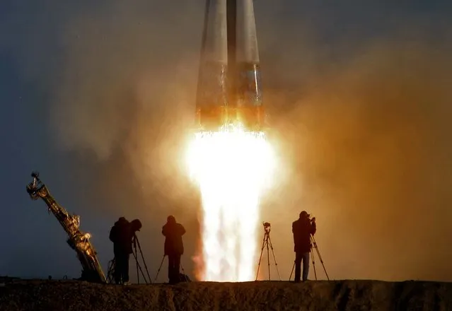 Cameramen film as the Soyuz-FG rocket booster carries the Soyuz TMA-11M with a new crew, as well as the Olympic flame representing the Sochi 2014 Winter Games, on November 7, 2013. to the International Space Station from the Russian leased Baikonur cosmodrome in Kazakhstan. (Photo by Dmitry Lovetsky/Associated Press)