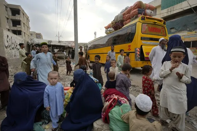 Afghan families wait to board into a bus to depart for their homeland, in Karachi, Pakistan, Friday, October 6, 2023. Pakistan's government announced a major crackdown Tuesday on migrants in the country illegally, saying it would expel them starting next month and raising alarm among foreigners without documentation who include an estimated 1.7 million Afghans. (Photo by Fareed Khan/AP Photo)