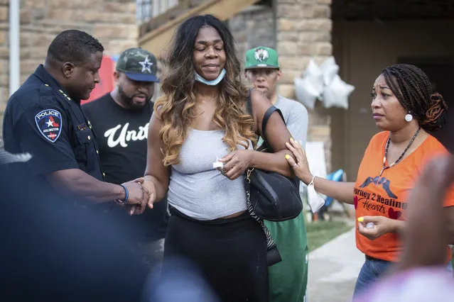 Arlington Police Chief, Al Jones, left, and Sharetta Sublet, center, the mother of two teens who died Friday, pray during a vigil Tuesday, July 27, 2021, at Artisan at Rush Creek in Arlington. (Photo by Yffy Yossifor/AP Photo)