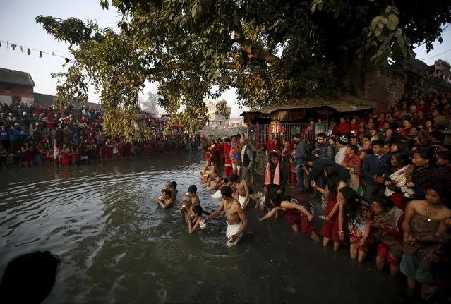 Devotees offer prayers by taking a bath in the Hanumante River, on the final day of the month-long Swasthani Brata Katha festival in Bhaktapur, Nepal, February 22, 2016. (Photo by Navesh Chitrakar/Reuters)