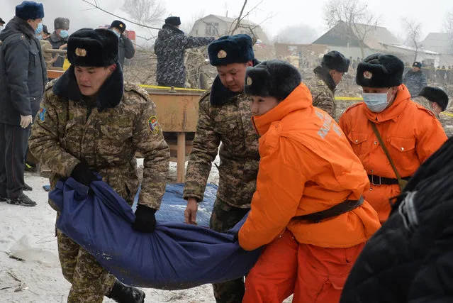Kyrgyz servicemen an rescuers carry a body bag with a victim at the crash site of a Turkish cargo plane in the village of Dacha-Suu outside Bishkek on January 16, 2017. (Photo by Vyacheslav Oseledko/AFP Photo)