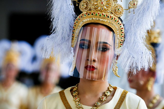 A performer wearing a face shield looks on during a ceremony held by the Bangkok National Museum to celebrate the return of two ancient relics, believed to have been stolen from Thailand about 60 years ago, from the United States, in Bangkok, Thailand on May 31, 2021. (Photo by Soe Zeya Tun/Reuters)