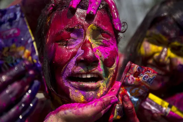 In this Thursday, March 21, 2019, file photo, an Indian girl grimaces as her face is smeared with colored powder during celebrations marking Holi, the Hindu festival of colors, in Gauhati, India. Holi also marks the advent of spring season. (Photo by Anupam Nath/AP Photo)