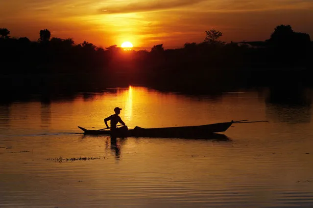 A fisherman paddles his boat on a lake during the sunset in Naypyitaw, Myanmar on Friday, December 2, 2016. (Photo by Aung Shine Oo/AP Photo)