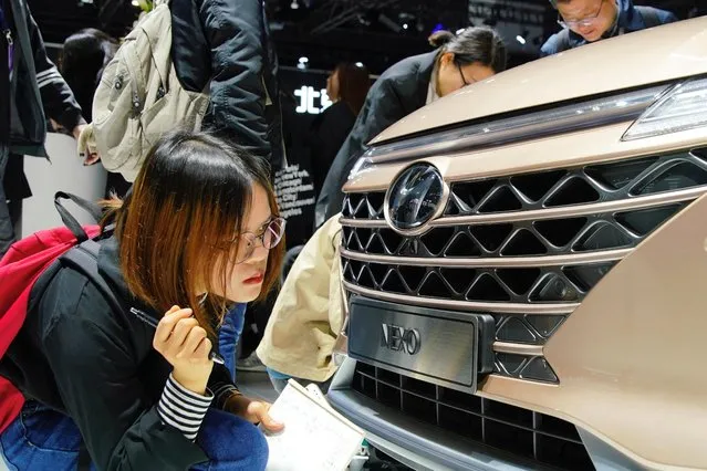 A journalist looks at the front of a Hyundai Nexo car presented during the media day for Shanghai auto show in Shanghai, China April 16, 2019. (Photo by Aly Song/Reuters)