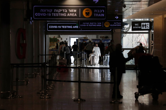 Passengers arrive to Israel's Ben Gurion Airport in Lod, east of Tel Aviv, on November 28, 2021. Israel is to close its borders to all foreigners on November 28, 2021 in a bid to stem the spread of the new Omicron variant of the coronavirus, authorities said. The government's latest announcement came just hours before the start at sundown of the eight-day-long Jewish holiday of Hanukkah, the Festival of Lights. (Photo by Ahmad Gharabli/AFP Photo)
