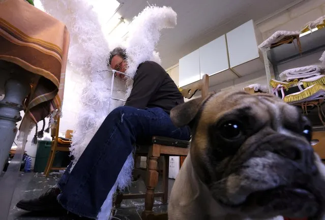 Louis Kersten, 82, artisan and renter of costumes for “Gilles of Binche” adjusts an ostrich feather hat in his workshop that will be worn by a performer during the Binche carnival, a UNESCO World Heritage event, in Binche, Belgium on January 24, 2023. (Photo by Yves Herman/Reuters)