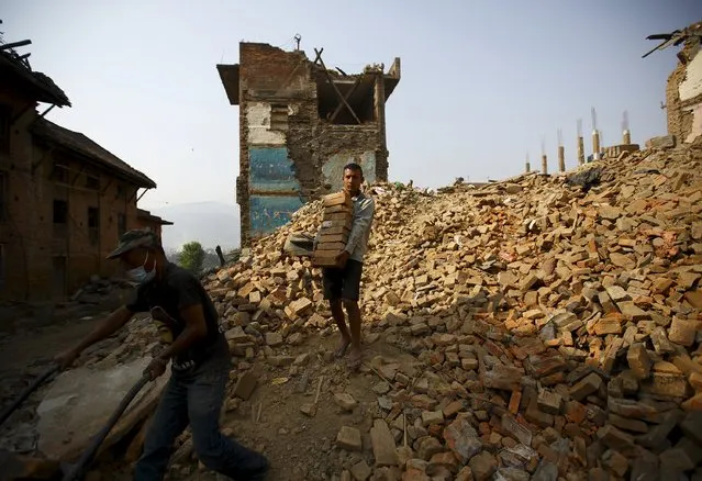 A man carries bricks from collapsed houses, a month after the April 25 earthquake in Kathmandu, Nepal May 25, 2015. (Photo by Navesh Chitrakar/Reuters)