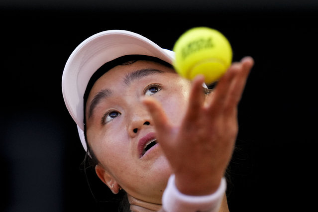 Xiyu Wang, of China, serves a ball to Iga Swiatek, of Poland, during the Mutua Madrid Open tennis tournament in Madrid, Thursday, April 25, 2024. (Photo by Manu Fernandez/AP Photo)