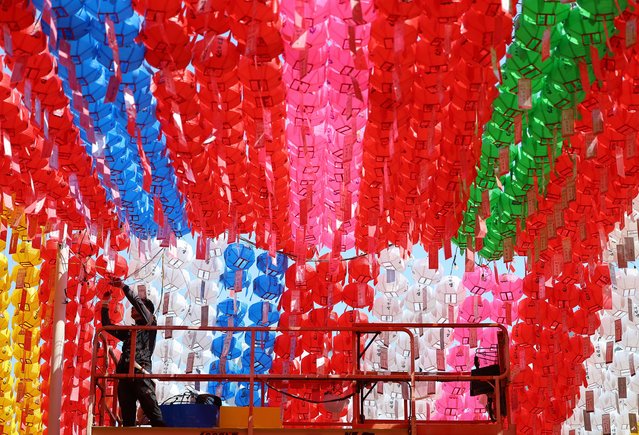 A worker hangs lotus lanterns ahead of Buddha's Birthday, at Jogye Temple in Seoul, South Korea, 12 April 2024. Buddha's Birthday will be celebrated on 15 May. (Photo by Yonhap/EPA)