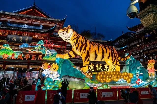 This photo taken on January 19, 2022 shows people watching a lantern of tiger at a lantern show in Yuyuan Garden in Shanghai, ahead of the Lunar New Year. (Photo by AFP Photo/China Stringer Network)