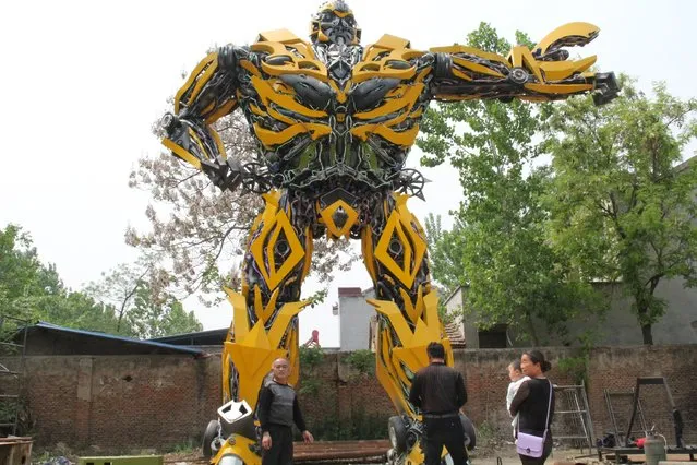 People look at a replica of a “Transformer”, made by a fan, in Shangqiu, Henan Province, China, April 22, 2016. According to local media, the owner took a year to build the replica, which is made of vehicle components and weighted about 17 tons. (Photo by Reuters/Stringer)