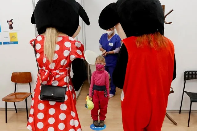 Medical staff members wearing costumes stand in front of a child who received a shot of the coronavirus disease (COVID-19) vaccine at a mass vaccination center in Prague, Czech Republic, January 8, 2022. (Photo by David W. Cerny/Reuters)