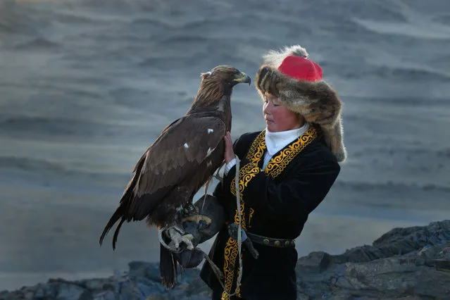 13 year old Ashol Pan with her eagle – Despite her young age, Ashol had the amazing ability to control and be able to caress her eagle, almost as if she had been with it for years. (Photo by Asher Svidensky/Caters News)