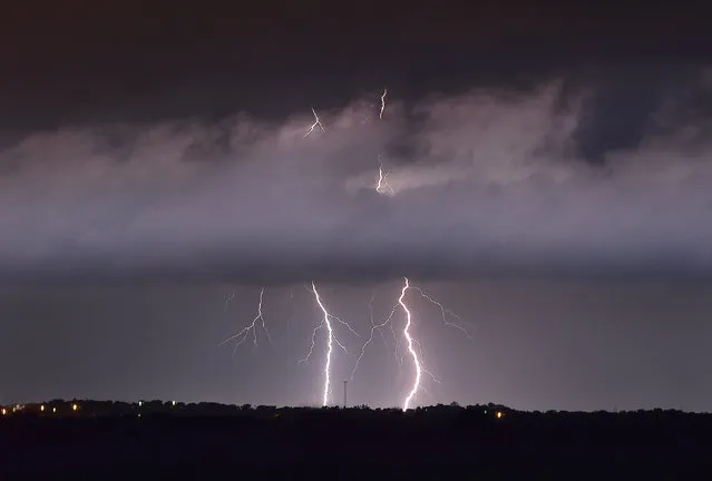 In this Wednesday, May 20, 2015 photo, lightning strikes between the towns of Krum and Sanger in Denton County, Texas, as a tornado warning was in effect for Sanger, Bolivar and Krum just after midnight. (Photo by Al Key/The Denton Record-Chronicle via AP Photo)