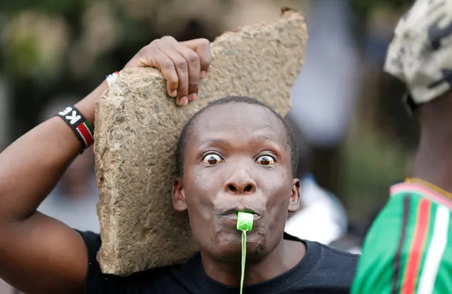 A Kenyan opposition Coalition for Reforms and Democracy (CORD) supporter carries a rock and blows a whistle during a protest at the premises hosting the headquarters of Independent Electoral and Boundaries Commission (IEBC) to demand the disbandment of the electoral body ahead of next year's election in Nairobi, Kenya, May 9, 2016. (Photo by Thomas Mukoya/Reuters)