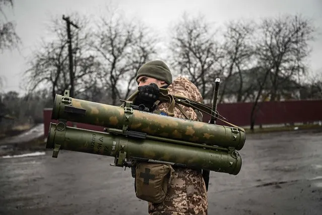 An Ukrainian soldier holds an anti-tank launcher at a frontline, northeast of Kyiv on March 3, 2022. (Photo by Aris Messinis/AFP Photo)