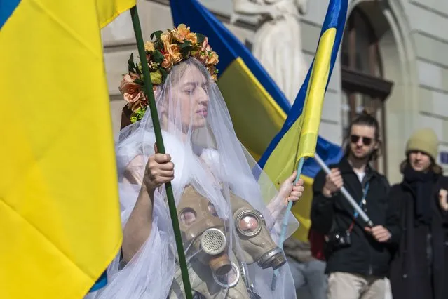 A protester wears a dress made from gas masks during a demonstration against the Russian invasion of Ukraine in Geneva, Switzerland, 05 March 2022. According to the United Nations (UN), at least one million people have fled Ukraine to neighboring countries since the beginning of Russia's military aggression on 24 February 2022. The UN estimates that around 160,000 Ukrainians are currently internally displaced. (Photo by Martial Trezzini/EPA/EFE/Rex Features/Shutterstock)