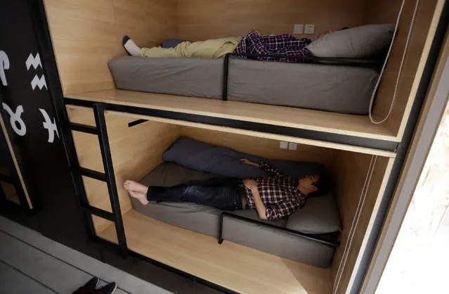 Wu Binbin (bottom) and Chen Huiyang, employees at BaishanCloud, take a nap after lunch in individual sleeping quarters, in the office, in Beijing, China, April 26, 2016. (Photo by Jason Lee/Reuters)