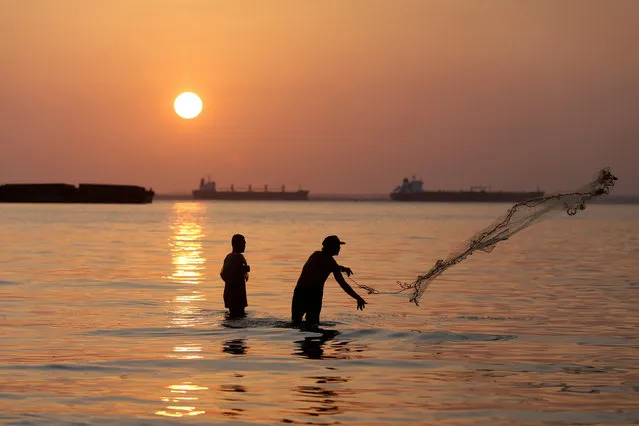 A fisherman throws his net to catch fish in Lake Maracaibo at dawn, in Maracaibo, Venezuela, February 4, 2017. (Photo by Marco Bello/Reuters)