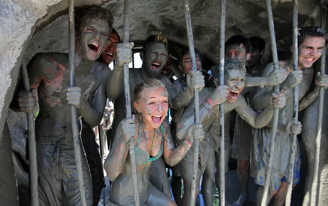 Mud-covered tourists pretend to be trapped inside a mud prison at the Daecheon Beach Mud Plaza in the city of Boryeong on South Korea's west coast, July 17, as they take part in the Boryeong Mud Festival, which opened that day and runs through July 26. Boryeong mud is rich in natural mineral component and is considered to prevent skin aging. (Photo by EPA/Yonhap)