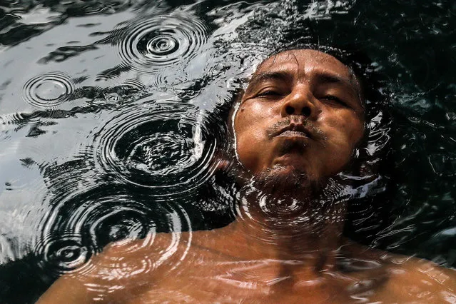 A man holds his breath while he swims inside hot spring on the occasion of World Water Day outside Kuala Lumpur, Malaysia, 22 March 2022. World Water Day celebrates water and raises awareness of the 2.2 billion people living without access to safe water. (Photo by Fazry Ismail/EPA/EFE)