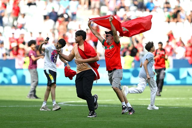 Fans of Morocco invade the pitch during the Men's group B match between Argentina and Morocco during the Olympic Games Paris 2024 at Stade Geoffroy-Guichard on July 24, 2024 in Saint-Etienne, France. (Photo by Tullio M. Puglia/Getty Images)