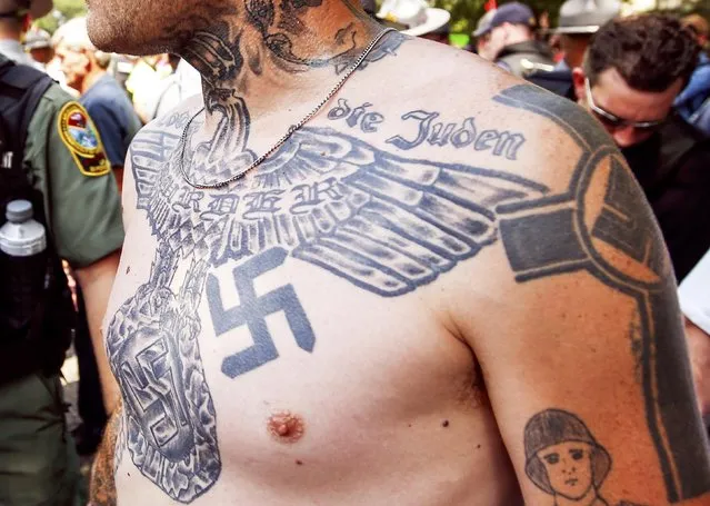A supporter of the Ku Klux Klan is seen with his tattoos during a rally at the statehouse in Columbia, South Carolina July 18, 2015. (Photo by Chris Keane/Reuters)