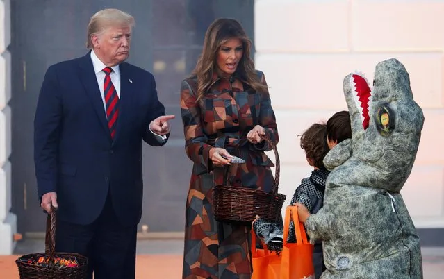 U.S. President Donald Trump and first lady Melania Trump hand out Halloween candy to visiting schoolchildren in advance of Halloween at the White House in Washington, U.S., October 28, 2019. (Photo by Tom Brenner/Reuters)