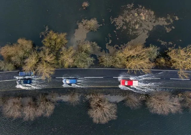 Cars make their way along the flooded A1101 in Welney in Norfolk, United Kingdom on Sunday, March 6, 2022. (Photo by Joe Giddens/PA Images via Getty Images)